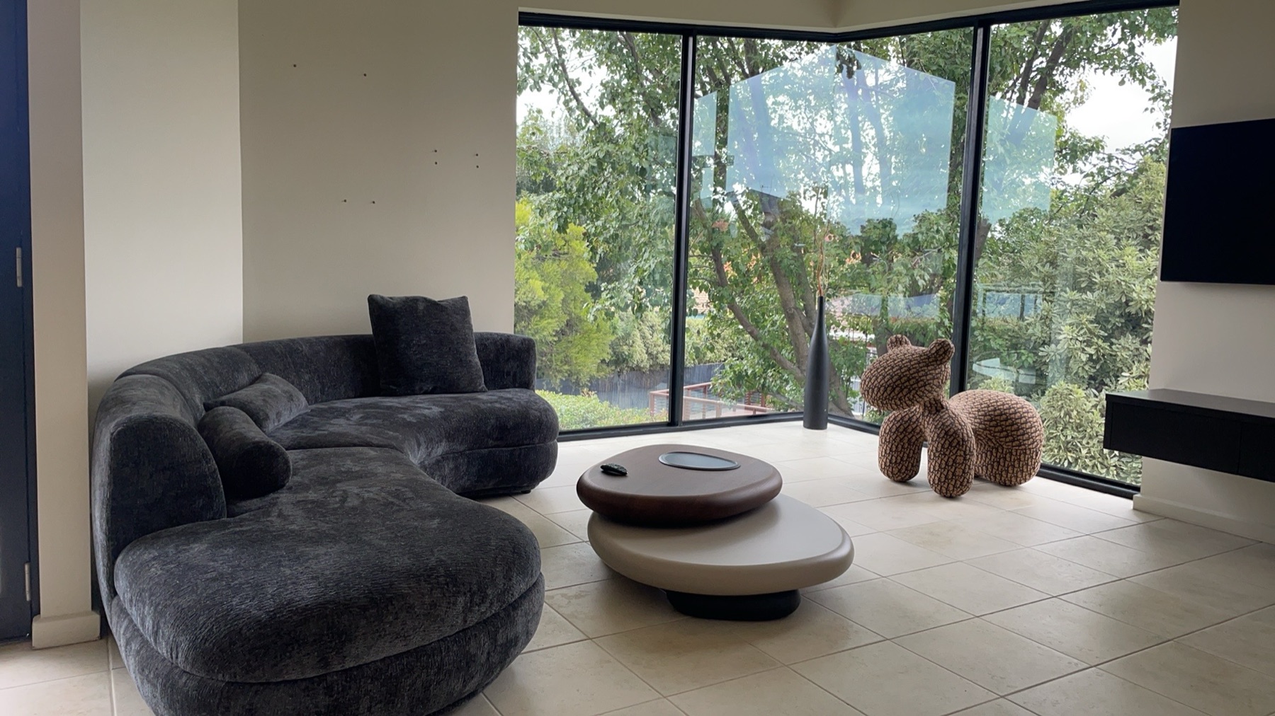 CXCASA custom lounge furniture project with dark sofa and garden windows